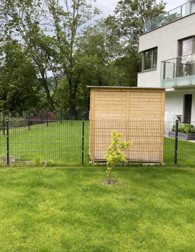 Schöner Garten mut einer kleinen Holzhütte und Gartenzaun